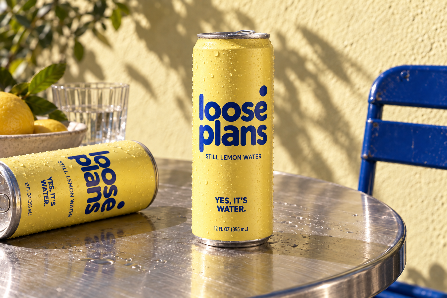 Yellow Loose Plans still lemon water cans on a sunlit café table.