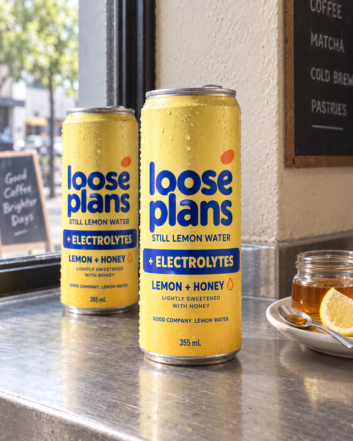 Loose Plans lemon and honey cans with electrolytes, beside a jar of honey.